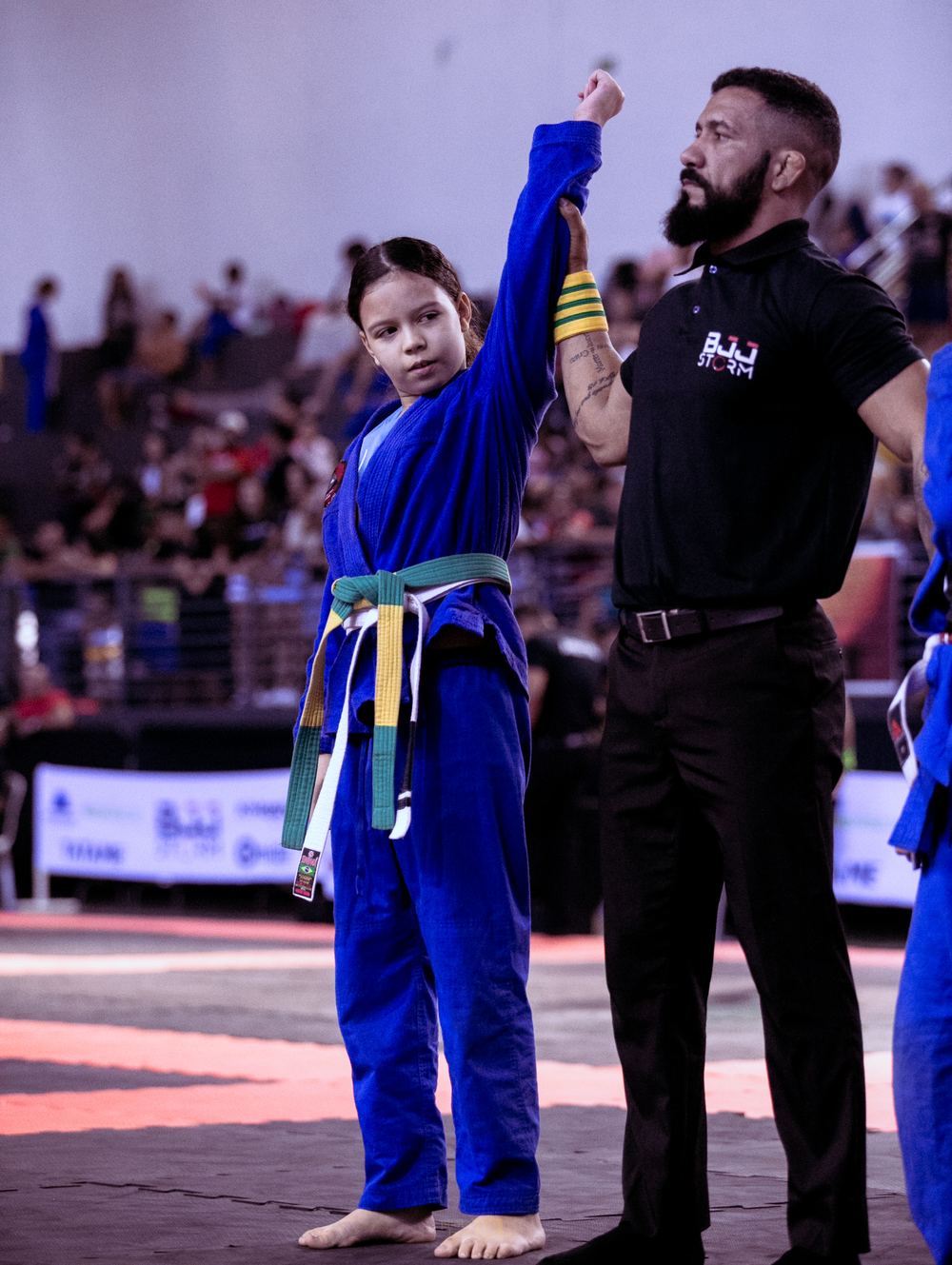 Ana Laura com o braço erguido, comemorando vitória no BJJ Storm