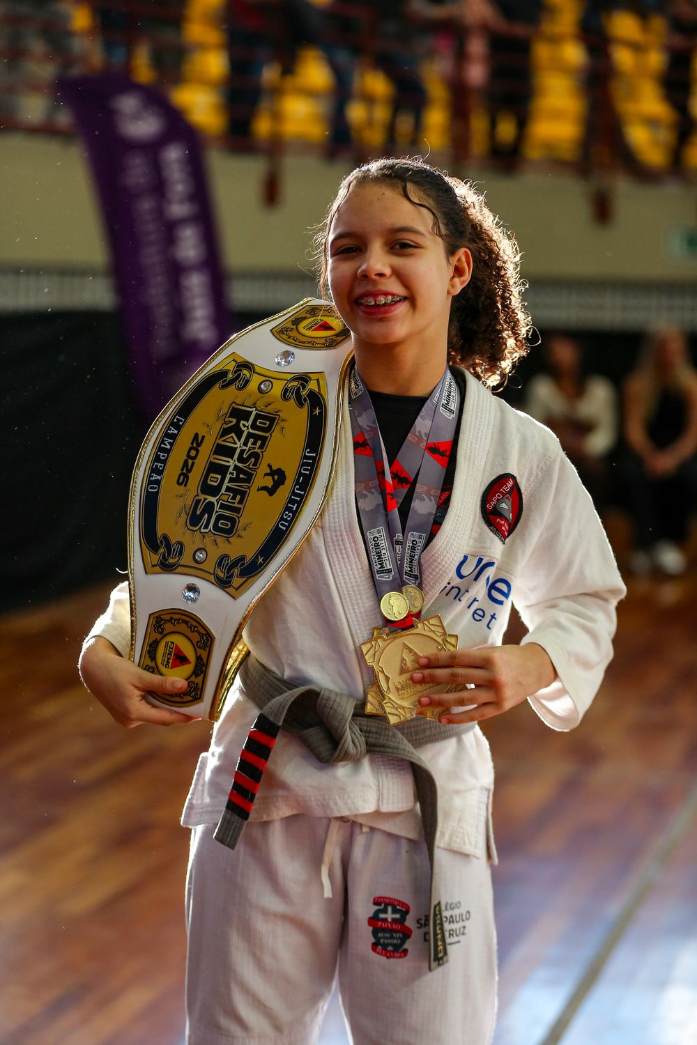 Ana Laura com o cinturão do Desafio Kids e as medalhas do Campeonato Mineiro