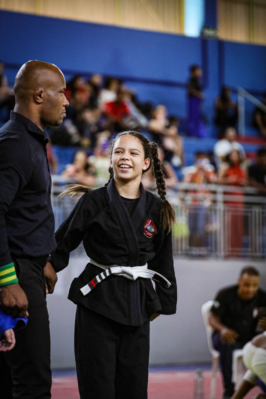 Ana Laura sorrindo ao lado do professor Andrei Alves em um campeonato